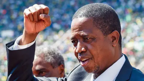 Edgar Lungu punching his fist into the air in a stadium