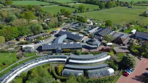 Raystede An aerial view of the centre with the aviaries in the fore ground and other buildings which have solar panels.