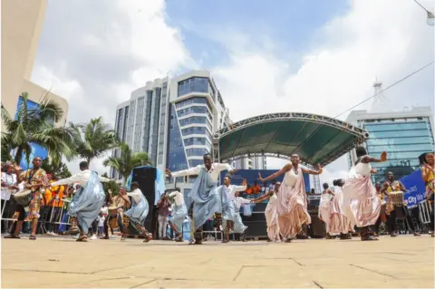 Getty Images People dancing outside wearing traditional attire.