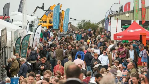 PA Media Hundreds of people walk around the Royal Cornwall Show with the tents and marquees up.