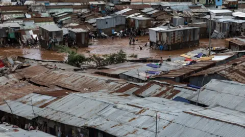 AFP via Getty Images Residents of Mathare slum try to salvage goods from their destroyed houses