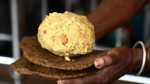 Famosos dulces sagrados en desagradable fila en India