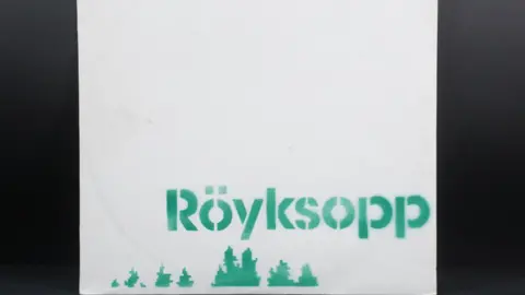 Martin Hughes A vinyl cover with with the word 'Röyksopp' in a green, stencilled format, and green pixelated treetops. 