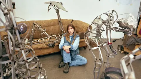 Lewis Ronald Kira Freije sitting amongst her sculptures from her exhibition Unspeak the Chorus, at The Hepworth Wakefield, November 2025