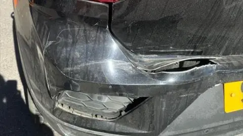 Sophie Rose Damage to the rear end of Sophie Rose's black car, displaying a large cut in the surface of the left-hand side of the boot