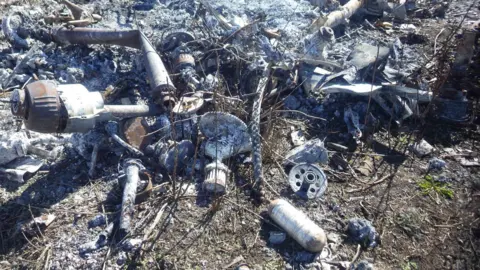 Royal Agricultural University Metal fragments of drone sit on a patch of land which has turned white due to the aftermath of a fire caused by the drone