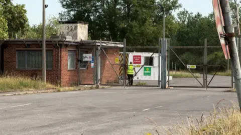 A former Mod site in Bicester. This shows the entrance gates next to a small red-brick gatehouse.