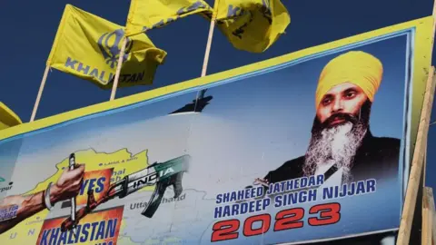 Reuters Sebuah mural menampilkan gambar mendiang pemimpin Sikh Hardeep Singh Nijjar, yang dibunuh di halaman kuil Guru Nanak Sikh Gurdwara pada Juni 2023, di Surrey, British Columbia, Kanada 18 September 2023. REUTERS/Chris Helgren