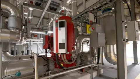PA Media A heat pump - a room full of large silver pipes