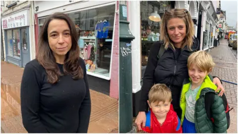 Catherine Hall and Susie Martinez and her two young sons in flooded streets in Monmouth