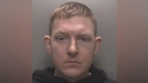 Leicestershire Police A mugshot of Nathan Gothard. He is looking straight ahead and is wearing a black hoody.