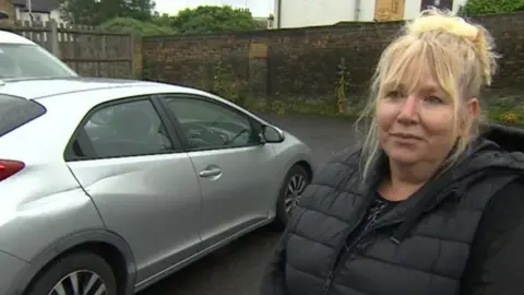 Rae Bottomley standing next to her damaged car