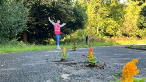 Harry Smith-Haggett Harry Smith-Haggett standing by the potholes with flowers in.