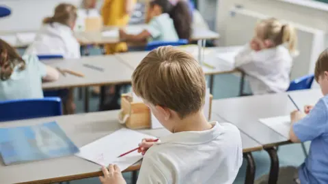 Getty Images Children sat at desks in a school - stock image