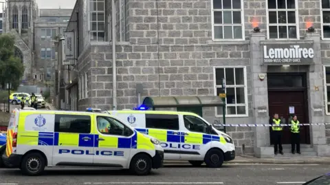 BBC police in front of a lemon tree