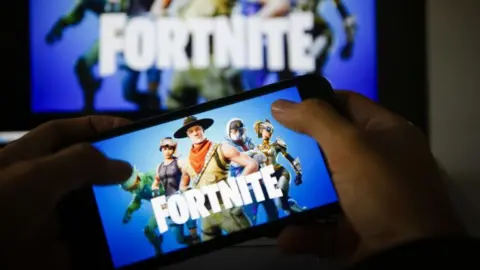 Getty Images Fortnite 로고가 있는 휴대폰을 들고 있는 두 손