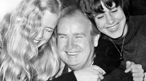 Getty Images Gwynfor Evans receives a hug from his daughters Meiniri (left) and Branwen (right)