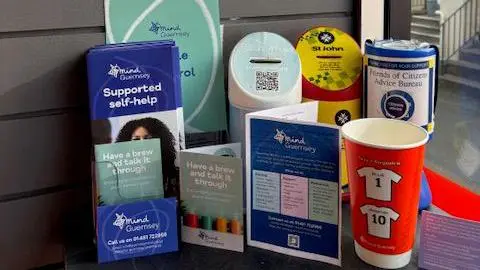 Roll Bar Mental health support information leaflets from Mind and a red memory cup in honour of the men who died.