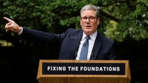 Getty Images Keir Starmer at the lectern with the words Fixing The Foundations 