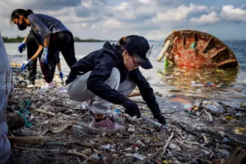 Ezra Acayan/Getty Images Volunteers collect plastic waste that washed up on the shores and mangroves of Freedom Island in Las Pinas, Metro Manila, Philippines. 15 September 2023