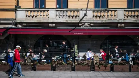 AFP People enjoy the spring weather as they sit at a restaurant in Stockholm on April 15, 2020,