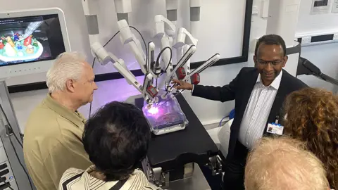 Visitors looking at the robot surgery machine