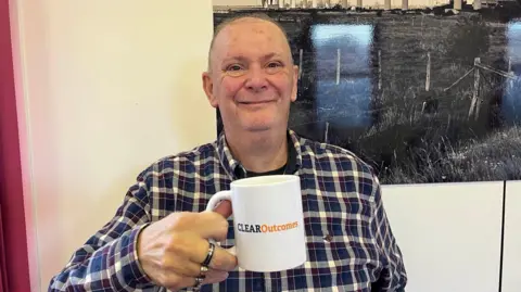 Mark Dixon at The Salvation Army Hall in Sheerness holding a cup of coffee