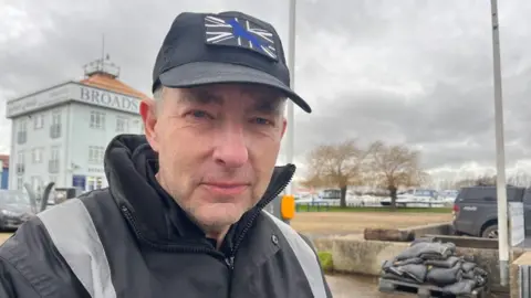 Andrew Turner/BBC Paul Rice pictured by flood defences in Potter Heigham