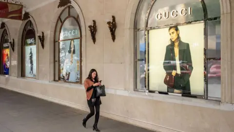 Getty Images Advertisements for Versace, left, and Gucci at the Trang Tien Plaza luxury shopping center in downtown Hanoi, Vietnam, on Tuesday, Feb. 27, 2024.