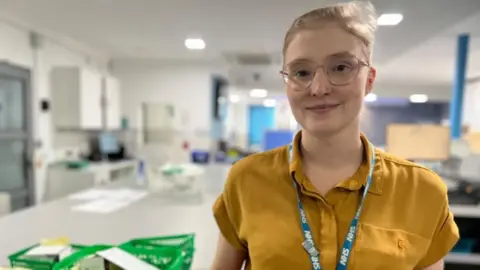 Emma Baugh/BBC Abby Chadwich wearing yellow top and NHS lanyard