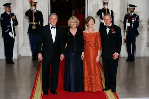 Getty Images George W Bush, the first lady, Queen Camilla and Charles. They are dressed nice, and standing on a red carpet