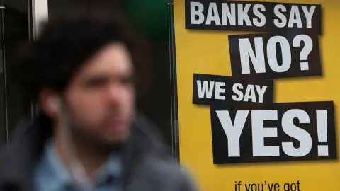 Man walks past payday lender billboard