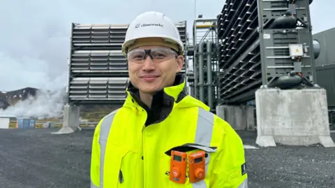 Douglas Chan of Climeworks stands in front of the large holes - part of the carbon capture plant