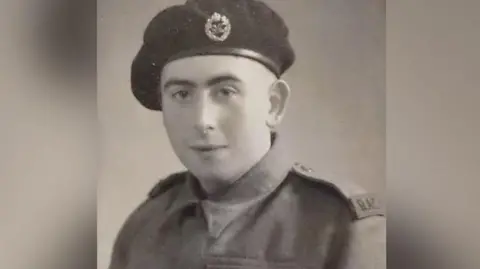 An old black and white headshot of a man in military uniform looking at the camera.