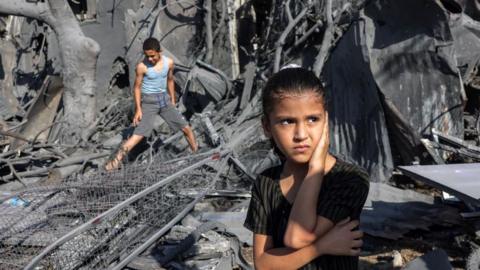 A girl looks on as she stands by the rubble outside a building that was hit by Israeli bombardment in Rafah in the southern Gaza Strip on 31 October 31 2023
