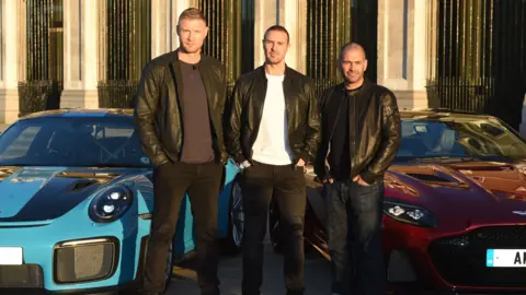 Getty Images Andrew Flintoff, Paddy McGuinness and Chris Harris standing in front of two cars