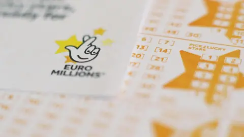 White and yellow Euromillions lottery slips seen stacked up