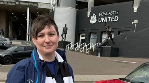 The Free Speech Union Linzi Smith outside St James' Park. She is wearing a Newcastle United scarf and has short brown hair.