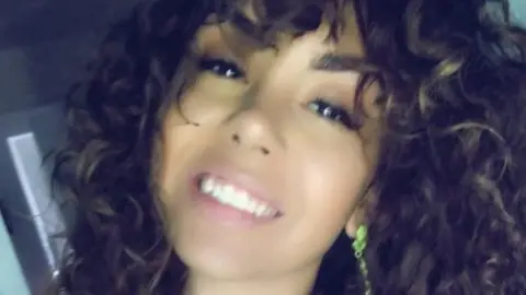 South Yorkshire Police A young woman with long, dark hair in loose curls and brown eyes smiles at the camera