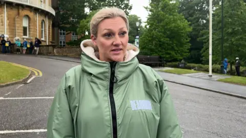 Natalie Clarke wearing a light green coat standing alongside a road outside Bournemouth Crown Court