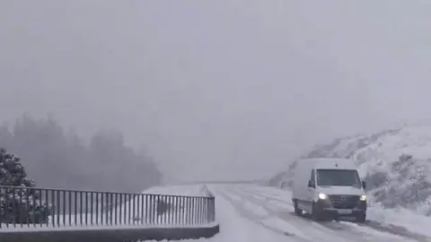 Van drives down snow-covered road