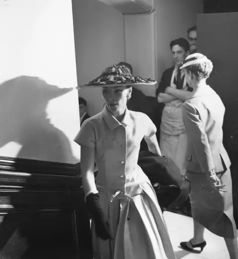 Thurston Hopkins/ Getty Images A periwinkle blue linen day dress, with a characteristically flattened bodice and pleated skirt, from Dior's 1955 collection.