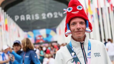 Volunteer is captured with the Olympic mascot hat during the torch relay ahead of the Summer Olympic Games Paris 2024