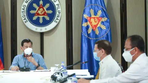 AFP Philippine President Rodrigo Duterte (L), Health Secretary Enrique Duque (R), and Carlito Galvez (C), chief implementer of the National Action Plan against COVID-19, listen over a meeting with members of the inter-Agency Task Force on the Emerging Infectious Diseases (IATF-EID) in Malacanang Palace in Manila on 8 April 2020