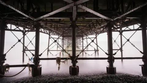 Getty Images A grey and murky morning underneath Worthing Pier