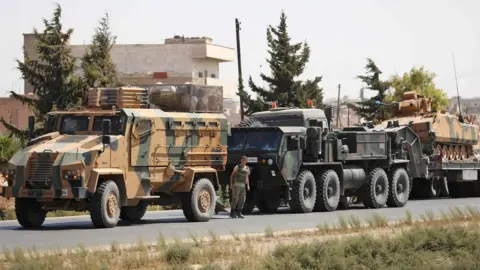 AFP Turkish military vehicles seen in a convoy near the Syrian town of Saraqeb, in Idlib province (29 August 2018)