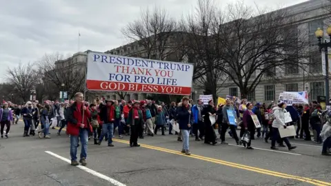 Ritu Prasad Marchers hold a sign saying president Trump, thank you for pro-life, god bless you