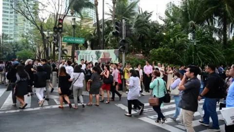 EPA People evacuate a building in Manila