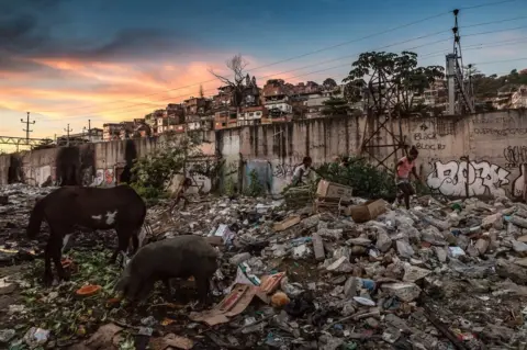 Tariq Zaidi Children play on one of the rubbish heaps at the "Favela" Vila do Metrô community, Mangueira, Rio de Janeiro, Brazil.