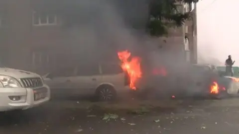 EPA Burning cars in Stepanakert, the capital of the disputed Nagorno-Karabakh region. Photo: 4 October 2020